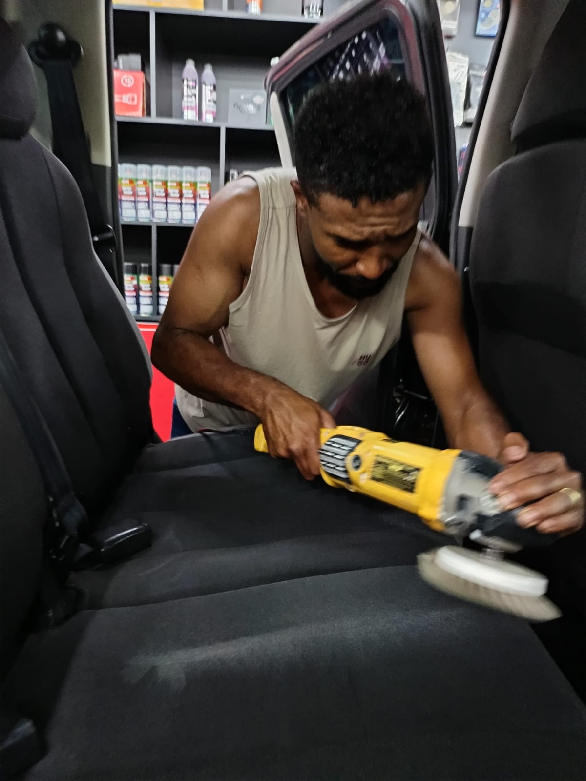 Profissional realizando higienização interna de banco automotivo